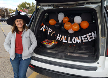A person standing next to a car with a hat and balloons in the back

AI-generated content may be incorrect.